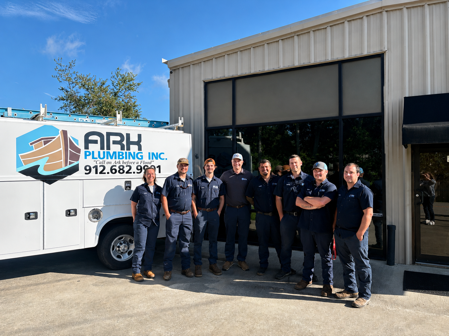 Ark Services team standing beside a branded service truck