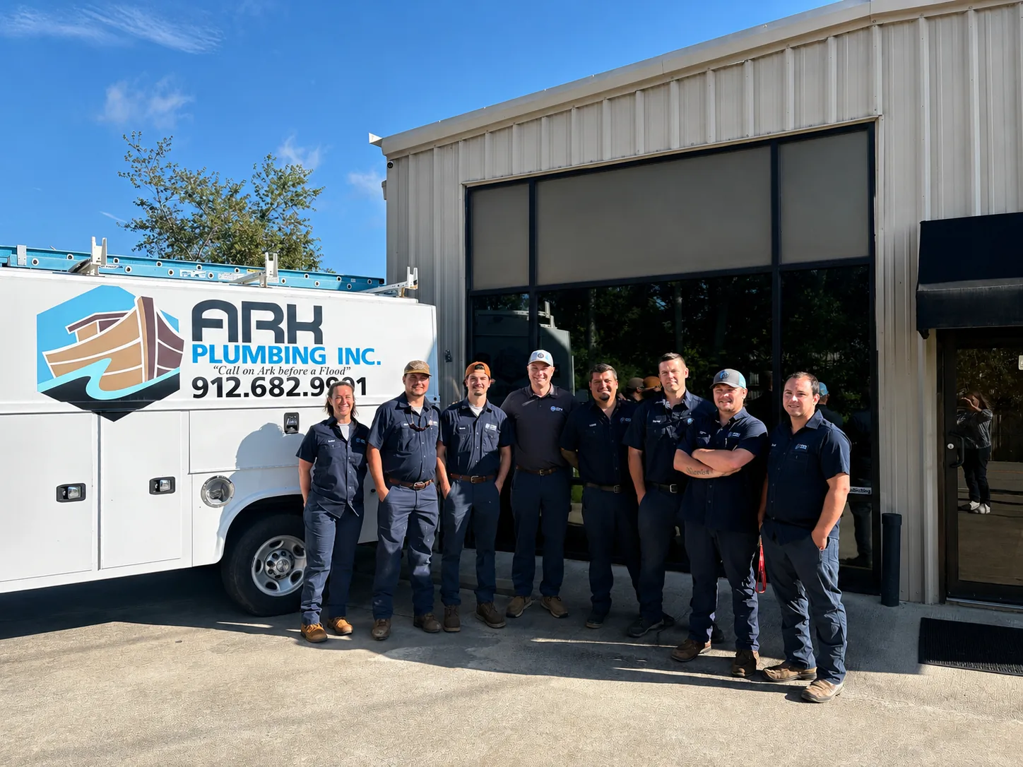 Ark Services team standing beside a branded service truck